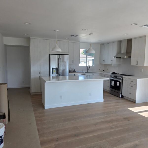 Remodeled open kitchen in Alhambra with an island and engineered hardwood floors