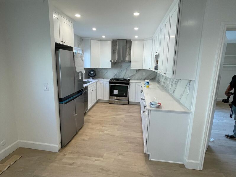 Remodeled condo kitchen in Arcadia, with white cabinets and a marble-look backsplash