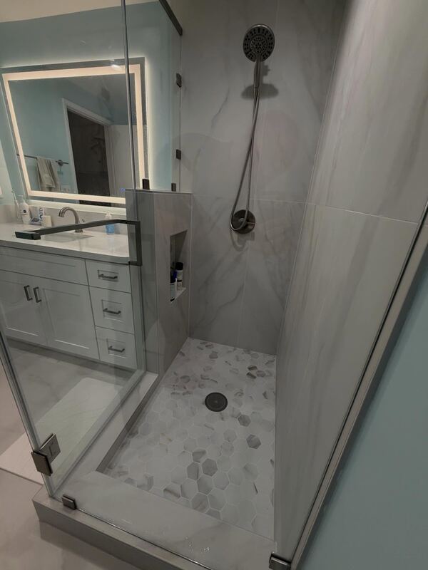 Glass shower with a pebble tile floor