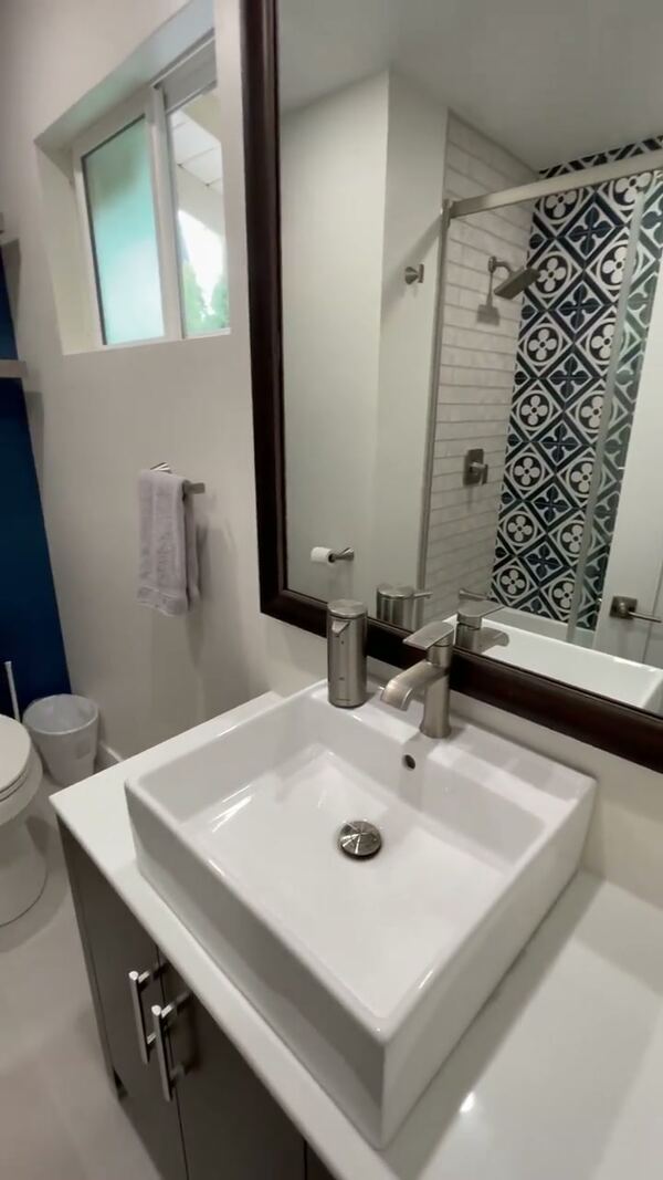 Vessel sink and vanity under a dark-framed mirror